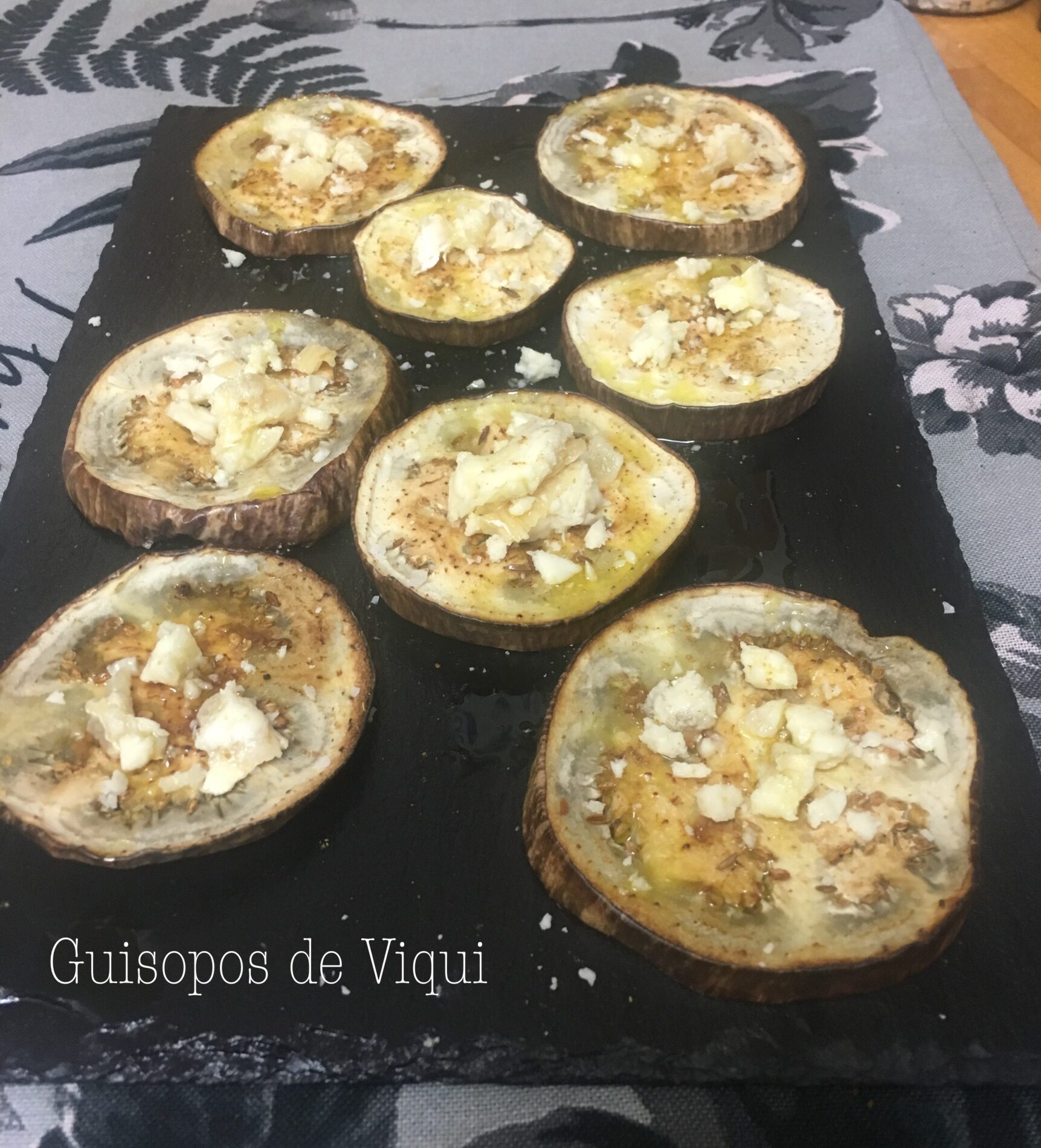 Albergínies al forn amb mel, comí i formatge de cabra